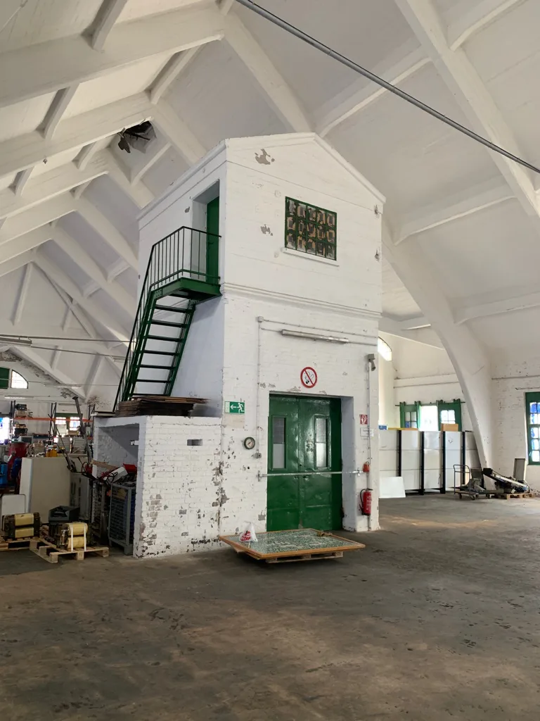 Innenansicht der GambTec Lagerhalle in Berlin mit Industrie-Holzdach